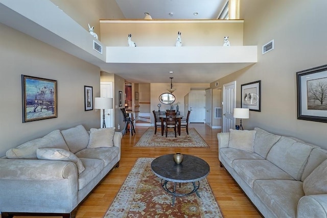 living room with a high ceiling and light hardwood / wood-style floors