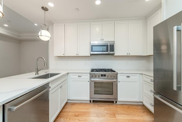 kitchen featuring tasteful backsplash, pendant lighting, sink, white cabinetry, and stainless steel appliances