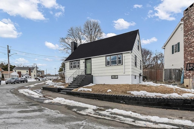 view of front of property featuring a chimney and fence