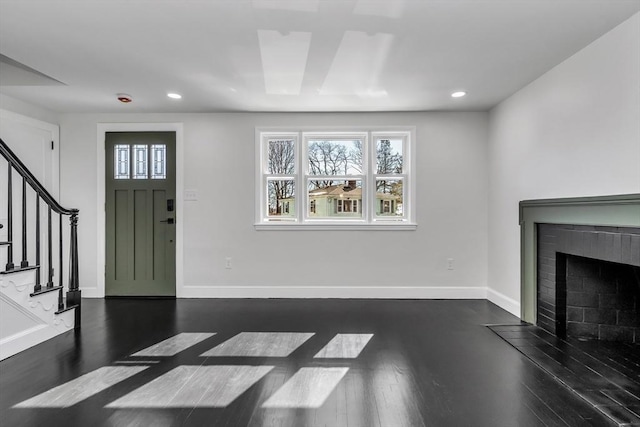 entrance foyer featuring stairway, dark wood-style floors, and baseboards