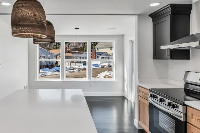 kitchen with dark wood-style floors, baseboards, light countertops, stainless steel range with electric stovetop, and wall chimney range hood