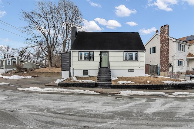 view of front of house with a chimney and fence