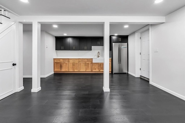 basement with high end fridge, a sink, recessed lighting, baseboards, and dark wood-style flooring