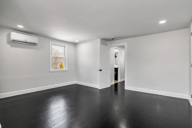 unfurnished room featuring recessed lighting, baseboards, dark wood finished floors, and a wall unit AC