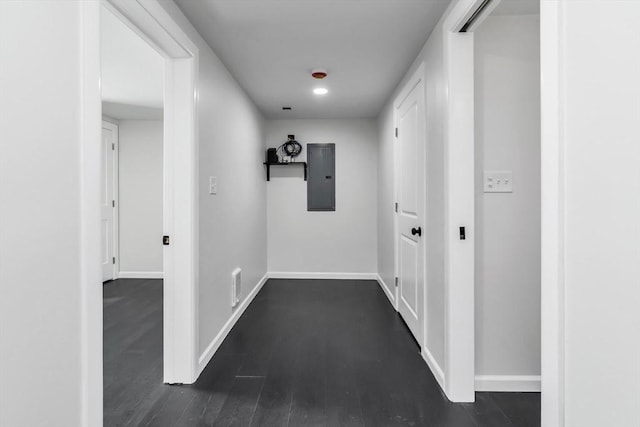 hall featuring dark wood finished floors, visible vents, electric panel, and baseboards