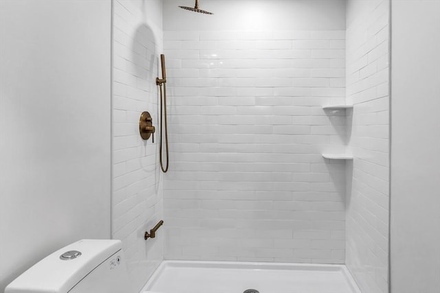 bathroom with tiled shower and toilet