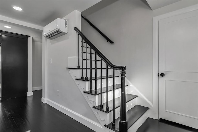 stairs with an AC wall unit, recessed lighting, wood finished floors, and baseboards