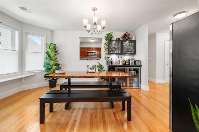 8 Brinton St Unit 2, Boston, MA 02119 - dining area featuring light wood-style flooring, baseboards, a bar, and a chandelier
