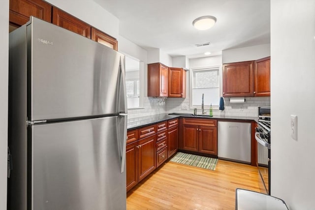 8 Brinton St Unit 2, Boston, MA 02119 - kitchen with stainless steel appliances, dark countertops, decorative backsplash, light wood finished floors, and a sink
