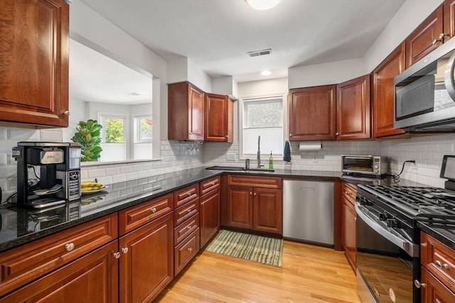 8 Brinton St Unit 2, Boston, MA 02119 - kitchen with stainless steel appliances, a sink, light wood finished floors, and tasteful backsplash
