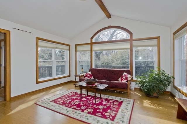 sunroom featuring vaulted ceiling with beams