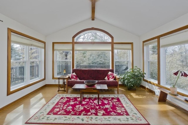 sunroom featuring vaulted ceiling with beams