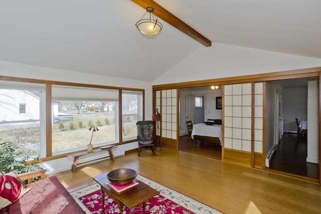 living area featuring wood finished floors and vaulted ceiling with beams