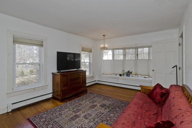 living area featuring a baseboard heating unit, wood finished floors, a wealth of natural light, and a baseboard radiator