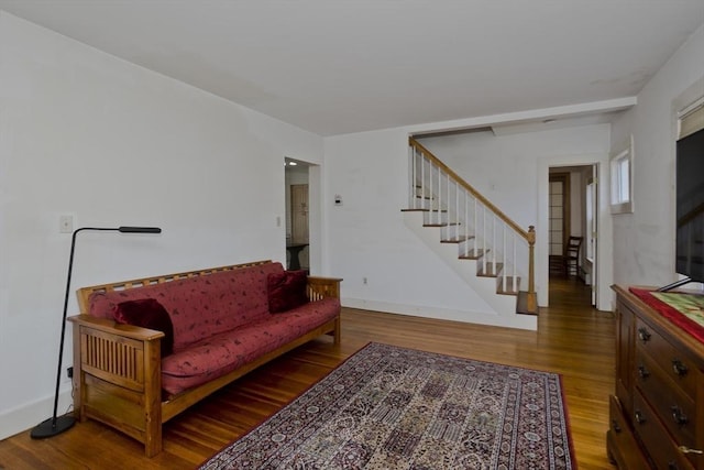 living room with stairway, baseboards, and wood finished floors