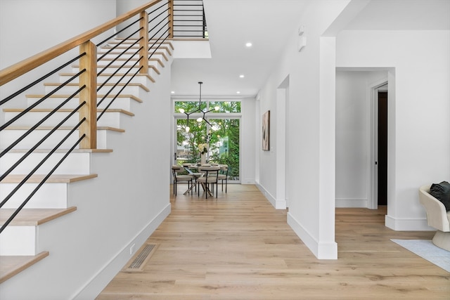 interior space with light hardwood / wood-style flooring, floor to ceiling windows, and a notable chandelier