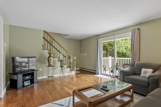 127 Bayberry Hill Ln Unit 127, Leominster, MA 01453 - living room with a baseboard radiator, wood finished floors, stairs, and baseboards