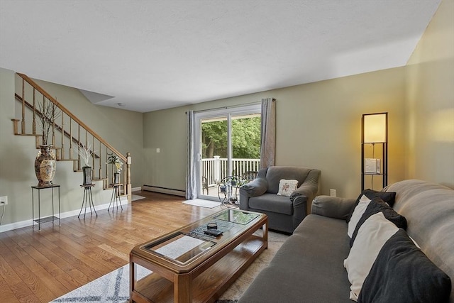 127 Bayberry Hill Ln Unit 127, Leominster, MA 01453 - living area with a baseboard heating unit, wood finished floors, stairs, and baseboards