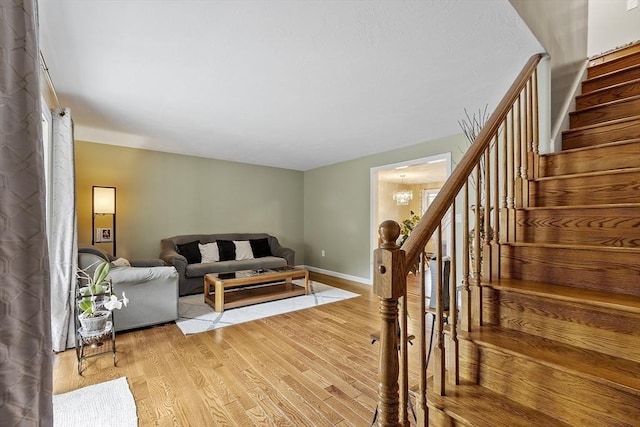 127 Bayberry Hill Ln Unit 127, Leominster, MA 01453 - living area with stairway, light wood finished floors, baseboards, and a chandelier
