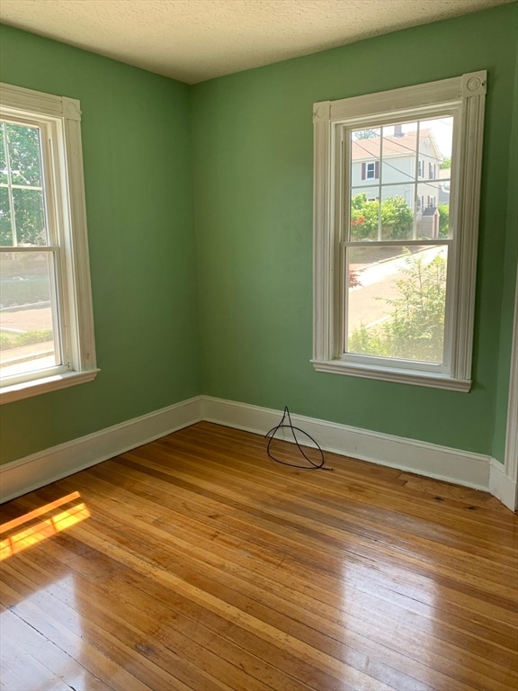 empty room featuring light hardwood / wood-style floors and a textured ceiling