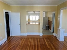 interior space with hardwood / wood-style floors and crown molding