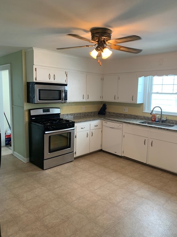 kitchen with backsplash, white cabinets, sink, ceiling fan, and stainless steel appliances