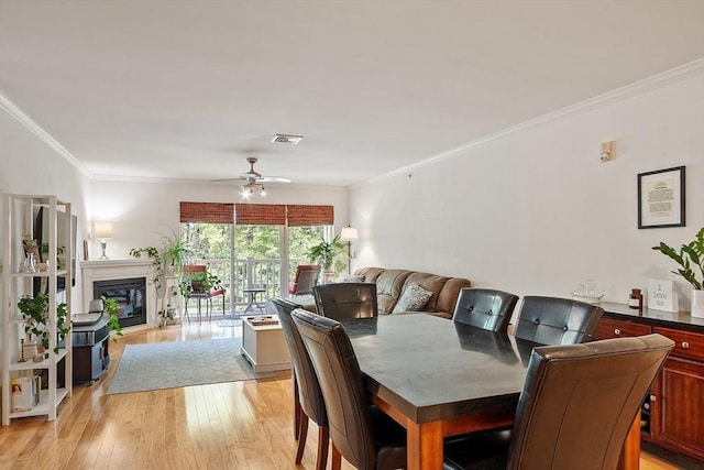 1818 Main St Unit 307, Holden, MA 01522 - dining space with ornamental molding, light wood-type flooring, ceiling fan, and a glass covered fireplace
