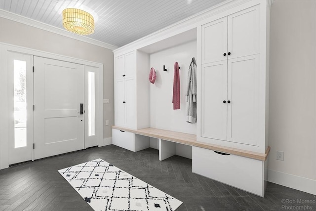 mudroom with plenty of natural light, dark parquet flooring, and ornamental molding