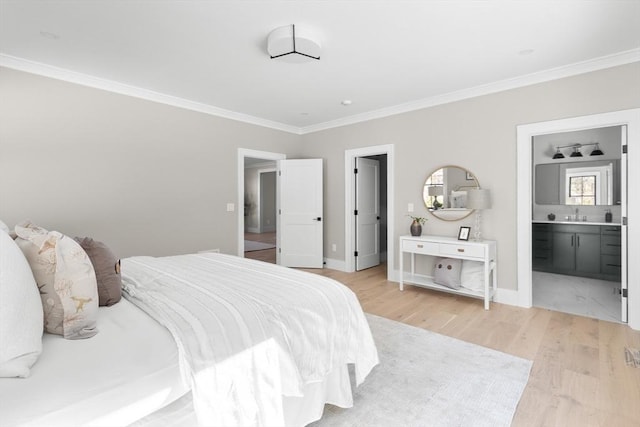 bedroom with light hardwood / wood-style floors, sink, ensuite bathroom, and crown molding