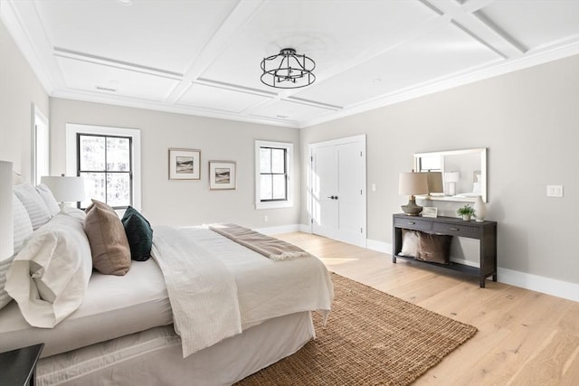 bedroom featuring crown molding, coffered ceiling, and light hardwood / wood-style floors