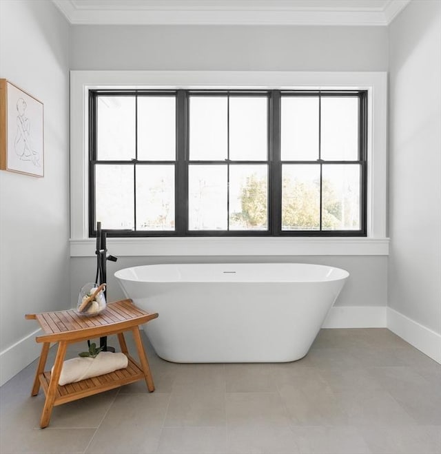 bathroom featuring a bathing tub, tile patterned flooring, and ornamental molding