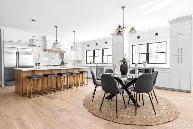 dining area with crown molding and light hardwood / wood-style flooring