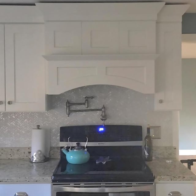 8 Caleb Rd, Shirley, MA 01464 - kitchen featuring stainless steel range with electric stovetop, white cabinetry, tasteful backsplash, and light stone countertops