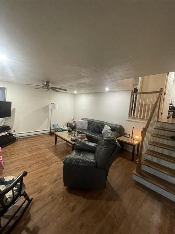 living room with a baseboard heating unit, hardwood / wood-style floors, and ceiling fan