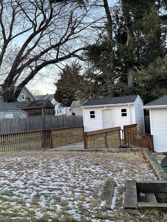 snowy yard featuring a shed and a wooden deck