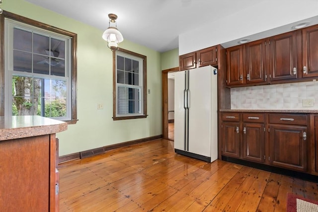 7 Martin St, Danvers, MA 01923 - kitchen with freestanding refrigerator, light wood-type flooring, backsplash, and pendant lighting