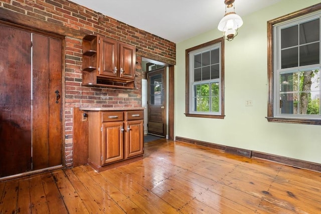 7 Martin St, Danvers, MA 01923 - kitchen featuring open shelves, light countertops, light wood-style flooring, brown cabinets, and decorative light fixtures