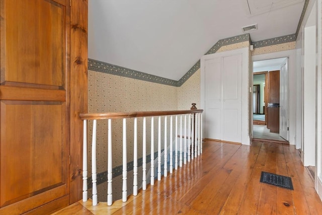 7 Martin St, Danvers, MA 01923 - hallway featuring wallpapered walls, wood-type flooring, vaulted ceiling, and attic access