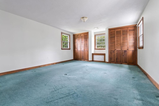 7 Martin St, Danvers, MA 01923 - unfurnished bedroom featuring two closets, multiple windows, and carpet