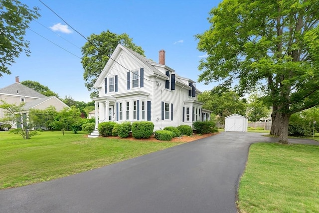 7 Martin St, Danvers, MA 01923 - view of front of home with a storage shed, a chimney, driveway, a front lawn, and a garage