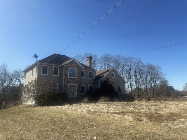 view of front of home featuring stone siding and a chimney