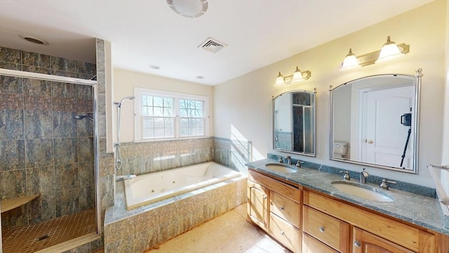 full bathroom with visible vents, a tub with jets, a sink, and tiled shower