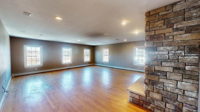 unfurnished living room with recessed lighting, a baseboard heating unit, wood finished floors, baseboards, and baseboard heating