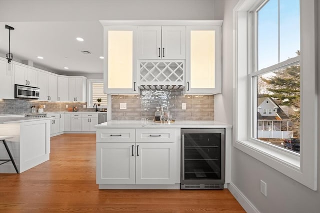 kitchen featuring wine cooler, light countertops, visible vents, appliances with stainless steel finishes, and white cabinets