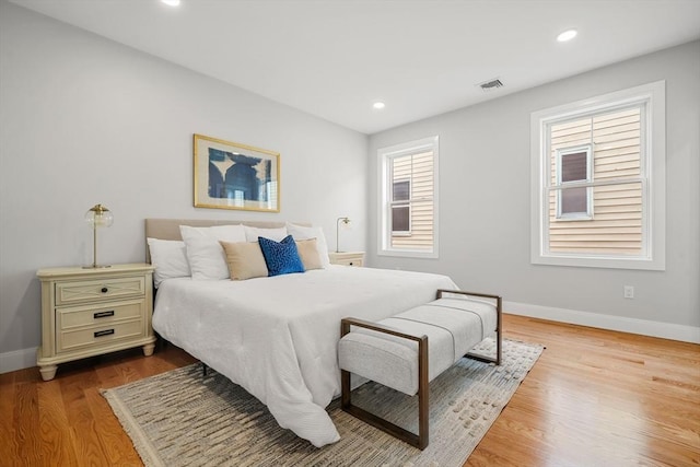 bedroom featuring recessed lighting, wood finished floors, visible vents, and baseboards