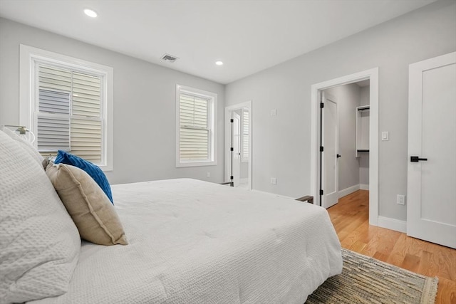 bedroom featuring light wood-type flooring, baseboards, visible vents, and recessed lighting