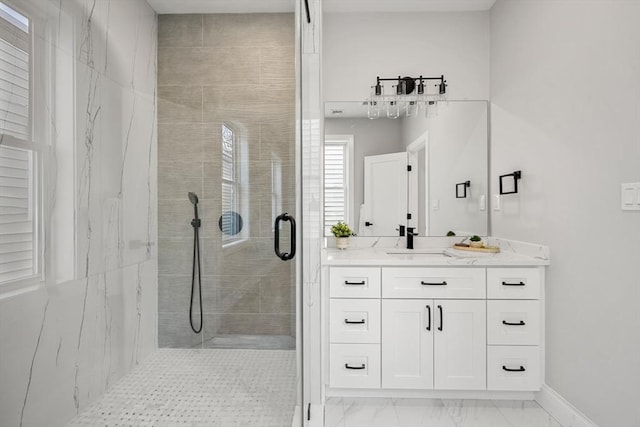 bathroom with a stall shower, baseboards, marble finish floor, and vanity