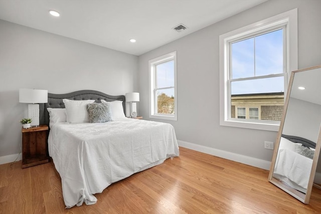 bedroom with light wood-type flooring, visible vents, baseboards, and recessed lighting