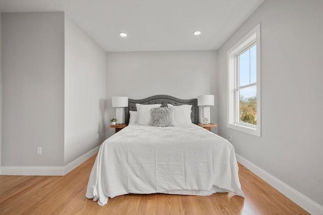 bedroom with baseboards, wood finished floors, and recessed lighting