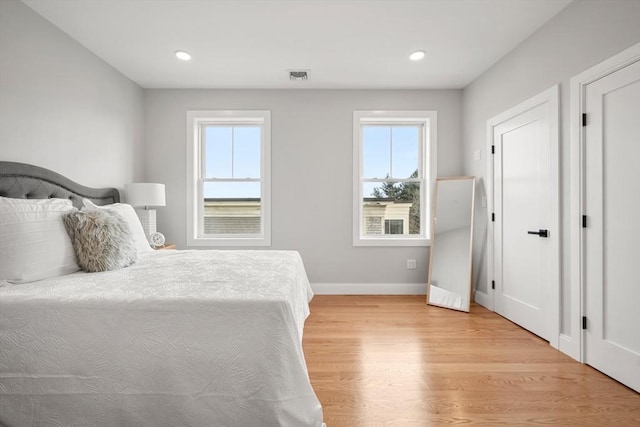 bedroom featuring recessed lighting, light wood-type flooring, visible vents, and baseboards